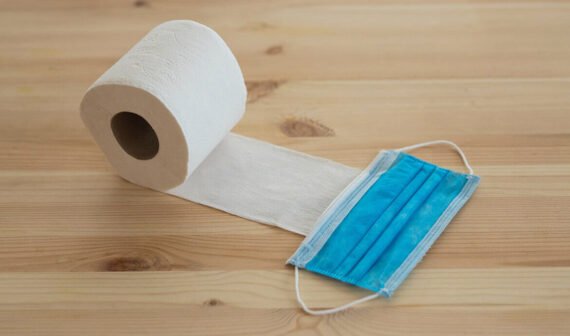 Osoba trzymająca się za bolącą łydkę, obok banany i awokado - objawy niedoboru potasu